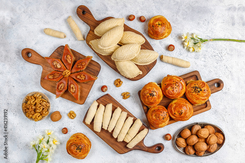 Traditional Azerbaijan holiday Novruz cookies baklava on the light background with nuts and shekerbura,qogal,mutaki,flat lay,top view,space for copy