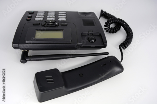 Stationary black plastic radio telephone, telephone with screen, tube and screwed cord. 