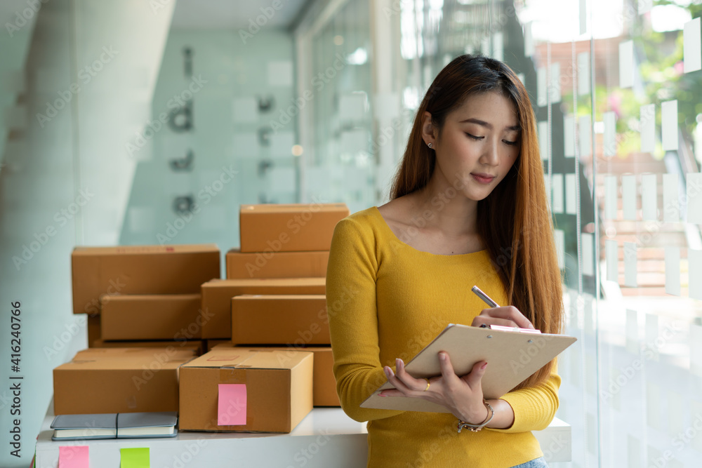 Start up successful small business owner, a freelance young Asian female merchant preparing a package box to deliver to customers, SME entrepreneurs, online business ideas, bloggers Start up successful small business owner, a freelance young Asian female merchant preparing a package box to deliver to customers, SME entrepreneurs, online business ideas, bloggers