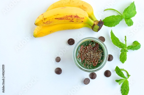 Spirulina mint banana smoothie with chocolate and chia seeds. White background
