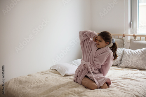 Tableau sur toile Little girl wakes up in her bed.