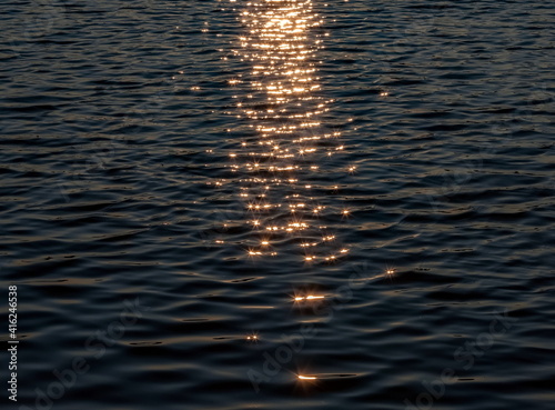 Reflections of the setting sun on the surface of the water reservoir