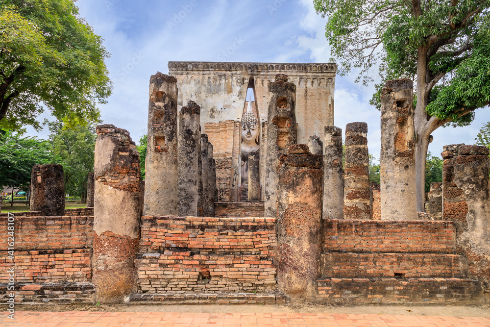 Famous big Buddha statue image named Phra Achana situated in ruined chapel at Wat Si Chum temple, Sukhothai Historical Park, Thailand Famous big Buddha statue image named Phra Achana situated in ruined chapel at Wat Si Chum temple, Sukhothai Historical Park, Thailand
