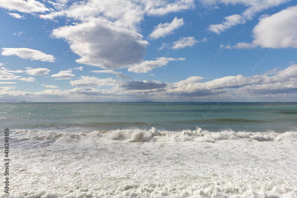 Fototapeta premium Waves crashing down with white foam on shore. Breaking waves