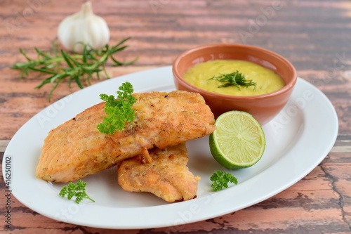 Fried salmon with potato puree garnish with lime and parsley