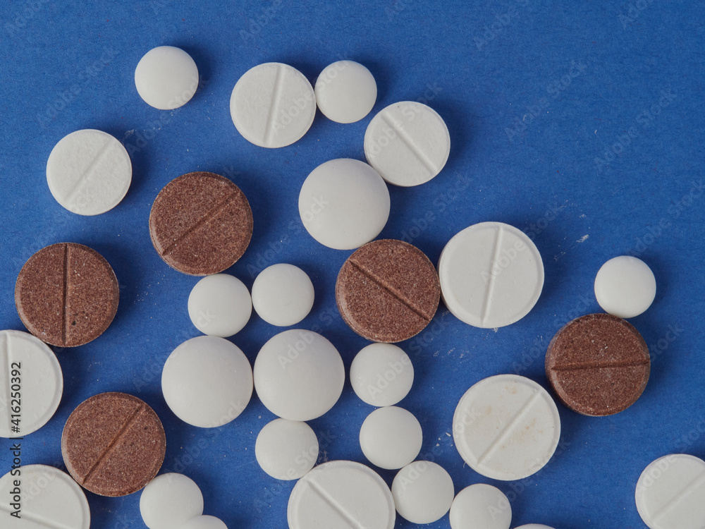various white tablets on a blue background various white tablets on a blue background