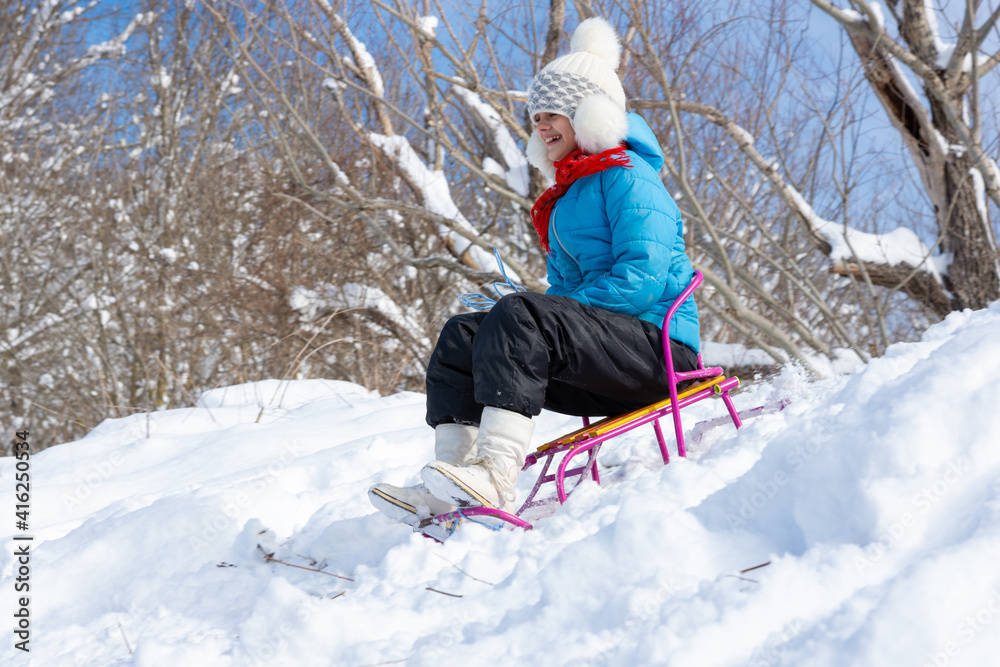 Girl sledding downhill in winter