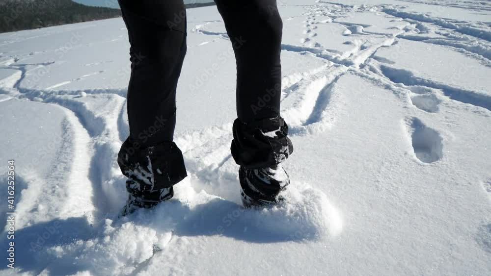 Man enjoy the ice skating rink in outdoor park. Legs wear hockey ice skates moving in deep snow on frozen lake. Slow motion from 180fps footage Man enjoy the ice skating rink in outdoor park. Legs wear hockey ice skates moving in deep snow on frozen lake. Slow motion from 180fps footage