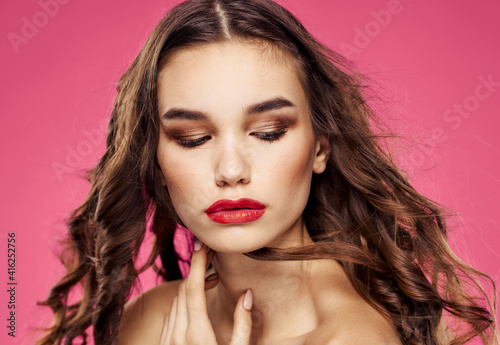 Red lips beautiful brunette curly hair pink background