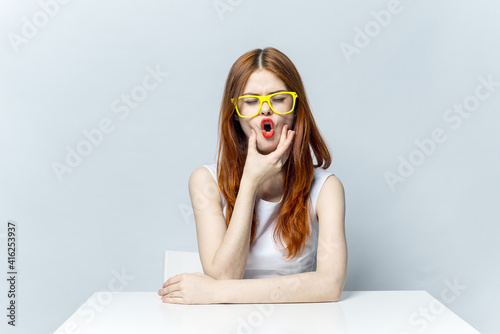 woman in yellow glasses sitting at the table smile 
