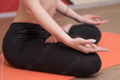 Close-up female hands that sits in the lotus position and shows a zen gesture