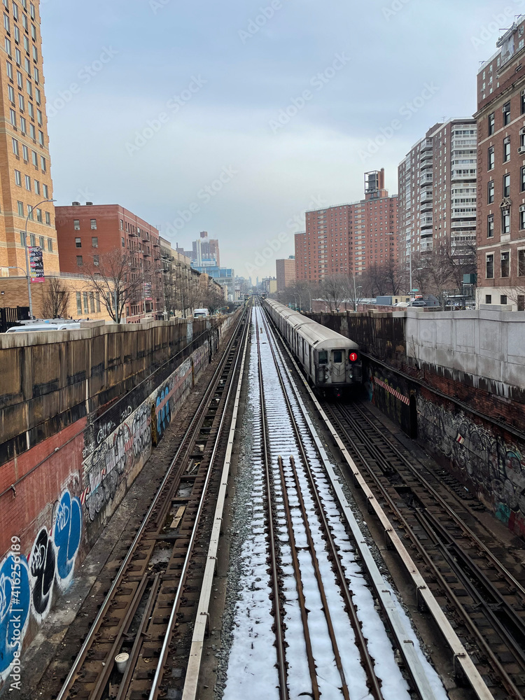 Manhattan, New York, USA. 2021. Subway train above ground leaving 125th station on snow covered tracks in the Morningside Heights district of Manhattan, NYC.