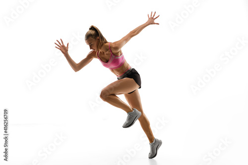 In jump. Caucasian professional female athlete, runner training isolated on white studio background. Muscular, sportive woman. Concept of action, motion, youth, healthy lifestyle. Copyspace for ad.