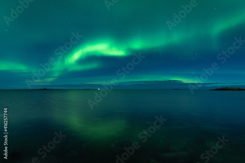 Aurora Borealis on the night sky above the sea © Adrian