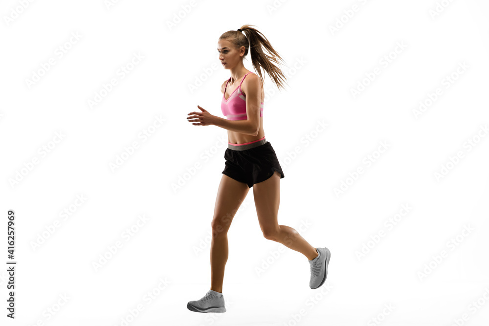 Strong. Caucasian professional female athlete, runner training isolated on white studio background. Muscular, sportive woman. Concept of action, motion, youth, healthy lifestyle. Copyspace for ad.