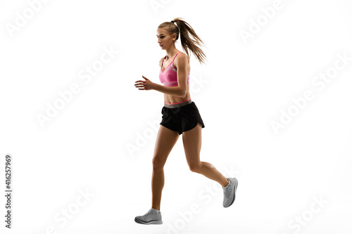 Strong. Caucasian professional female athlete, runner training isolated on white studio background. Muscular, sportive woman. Concept of action, motion, youth, healthy lifestyle. Copyspace for ad.