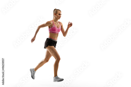 Strong. Caucasian professional female athlete, runner training isolated on white studio background. Muscular, sportive woman. Concept of action, motion, youth, healthy lifestyle. Copyspace for ad.