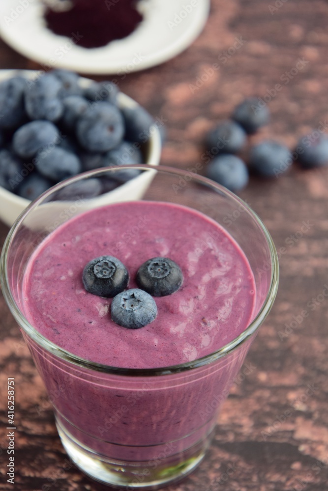 Fresh blueberry smoothie in a glass on wooden background. Selective focus Fresh blueberry smoothie in a glass on wooden background. Selective focus
