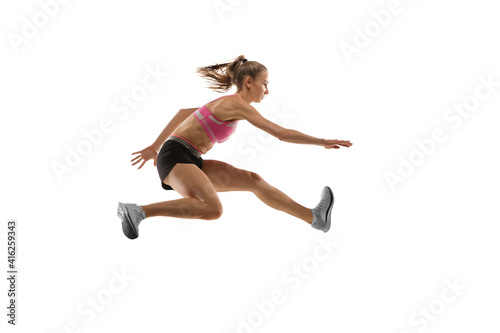 In jump. Caucasian professional female athlete  runner training isolated on white studio background. Muscular  sportive woman. Concept of action  motion  youth  healthy lifestyle. Copyspace for ad.
