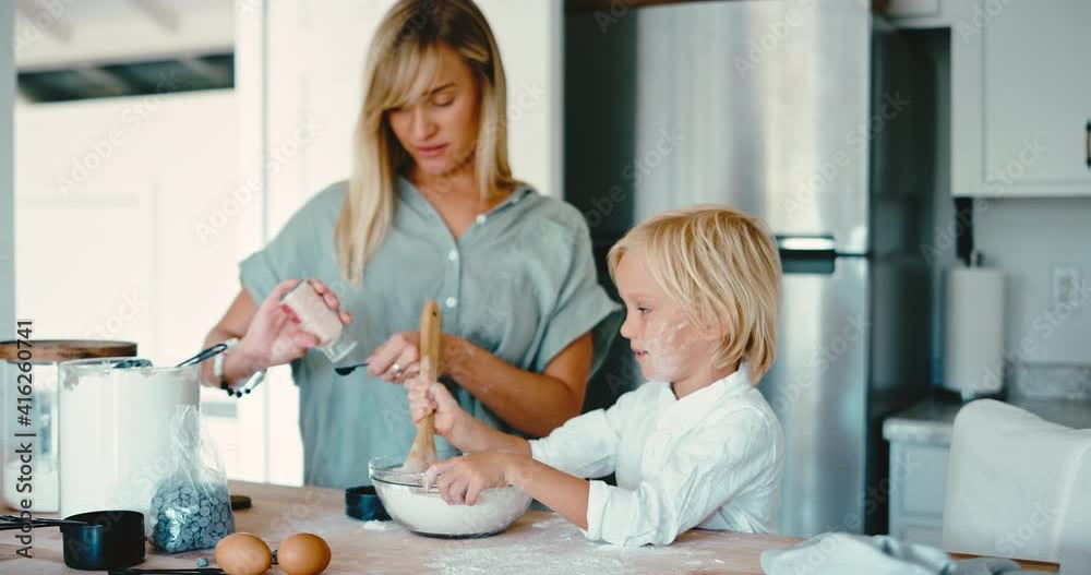 Happy loving young mother and son baking cookies together in the kitchen, quality time together with family, fun family lifestyle Happy loving young mother and son baking cookies together in the kitchen, quality time together with family, fun family lifestyle