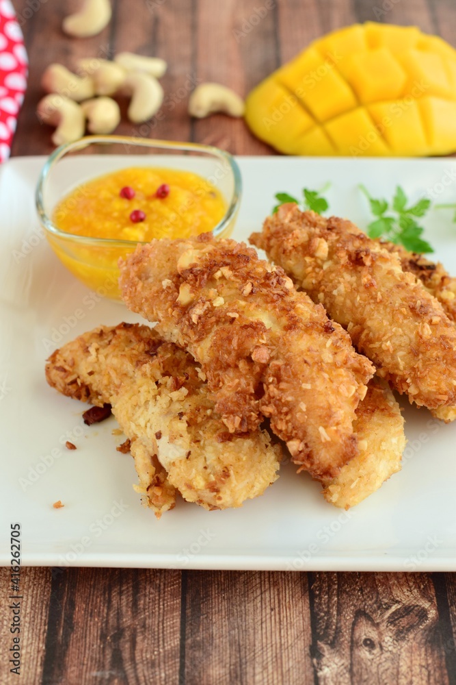 Chicken fingers breaded with cashew and coconut flakes. Served with mango red pepper dip Chicken fingers breaded with cashew and coconut flakes. Served with mango red pepper dip