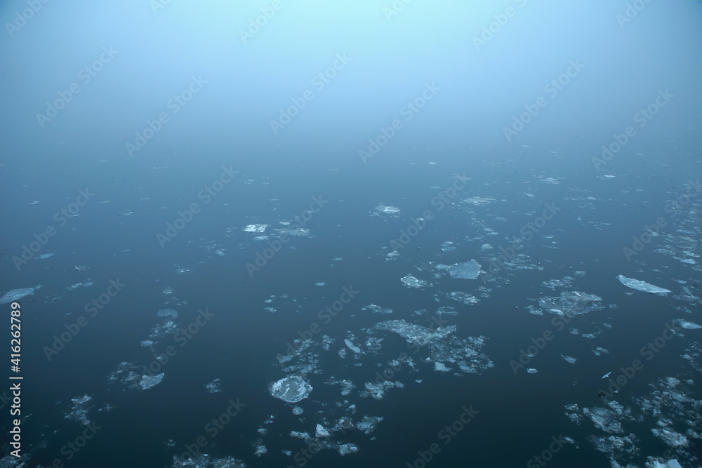 Fototapeta premium Misty icy blue water surface with endless fog on river Danube; color photo.