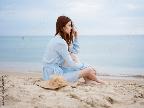 Beautiful woman wearing light clothes on the sand near the ocean in nature © SHOTPRIME STUDIO