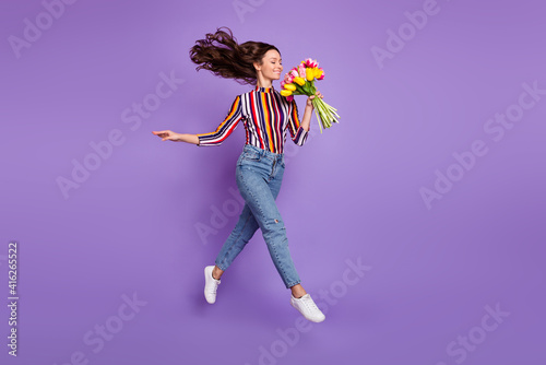 Full length body size photo of woman jumping high smelling tulip flowers scent isolated bright violet color background