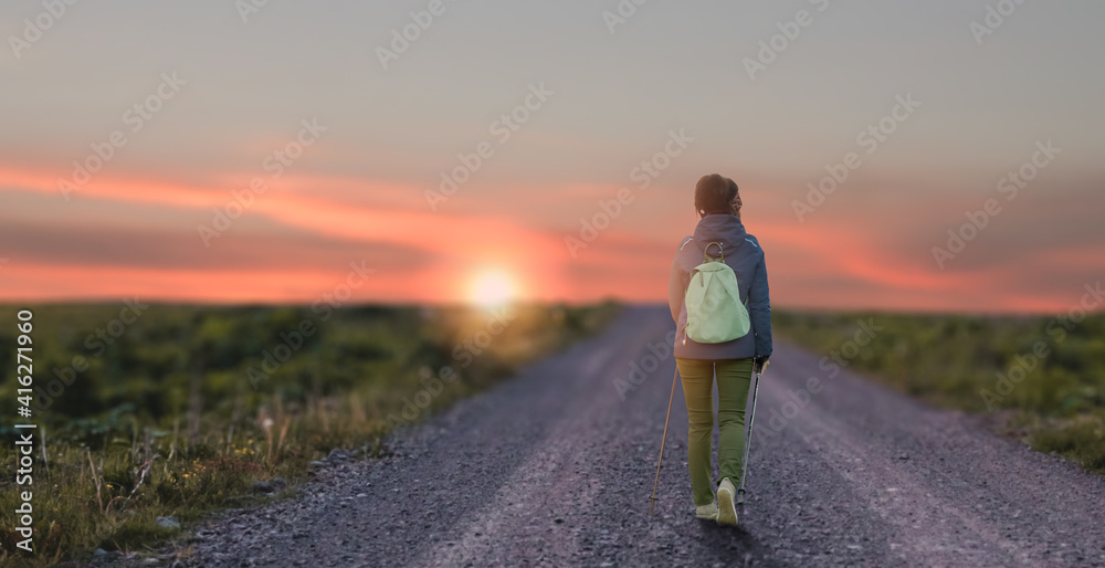 Hitchhiker traveller woman on the road in sunset Hitchhiker traveller woman on the road in sunset