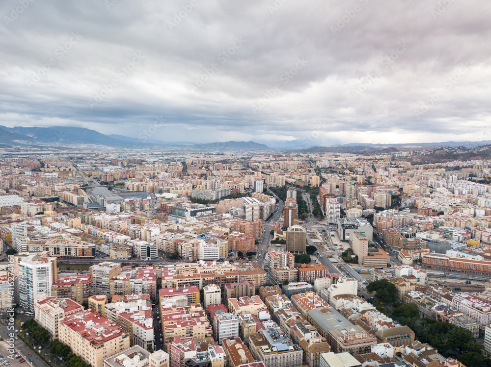 Aerial drone perspective of Andalusian city Malaga, touristic travel destination on Costa del Sol. Roof top , Cathedral of Malaga, Mountains in background, cloudy day Aerial drone perspective of Andalusian city Malaga, touristic travel destination on Costa del Sol. Roof top , Cathedral of Malaga, Mountains in background, cloudy day