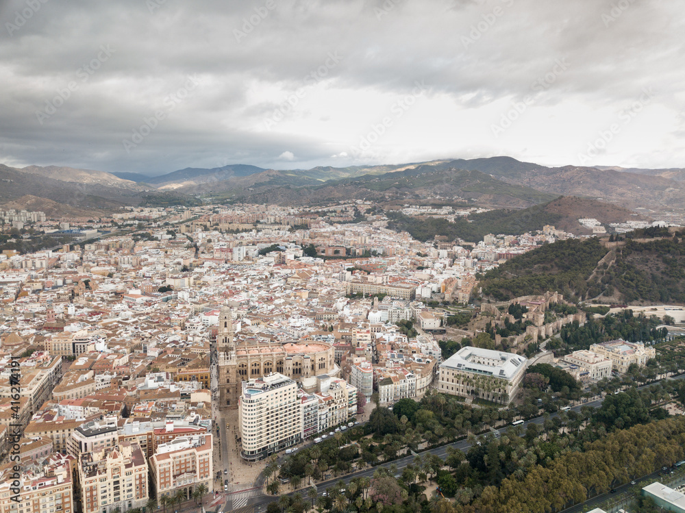 Aerial drone perspective of Andalusian city Malaga, touristic travel destination on Costa del Sol. Roof top , Cathedral of Malaga, Mountains in background, cloudy day