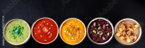 Vegan soup panoramic header with copyspace. Vegetable cream soups, shot from above on a black background