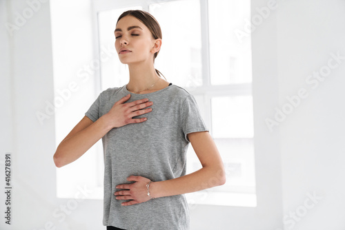 Athletic sportswoman doing breathing exercise during yoga practice photo