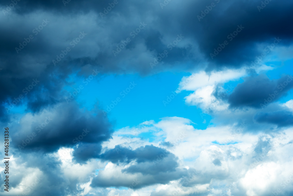 Fototapeta premium Blue sky with a frame of dark clouds and white clouds