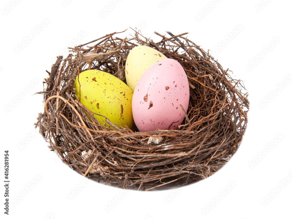 Obraz premium Colorful eggs in wooden bird nest isolated on the white background