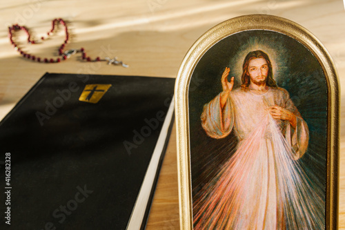 Catholic attributes. Icon of the Merciful Jesus, the Bible and the Holy Rosary photo