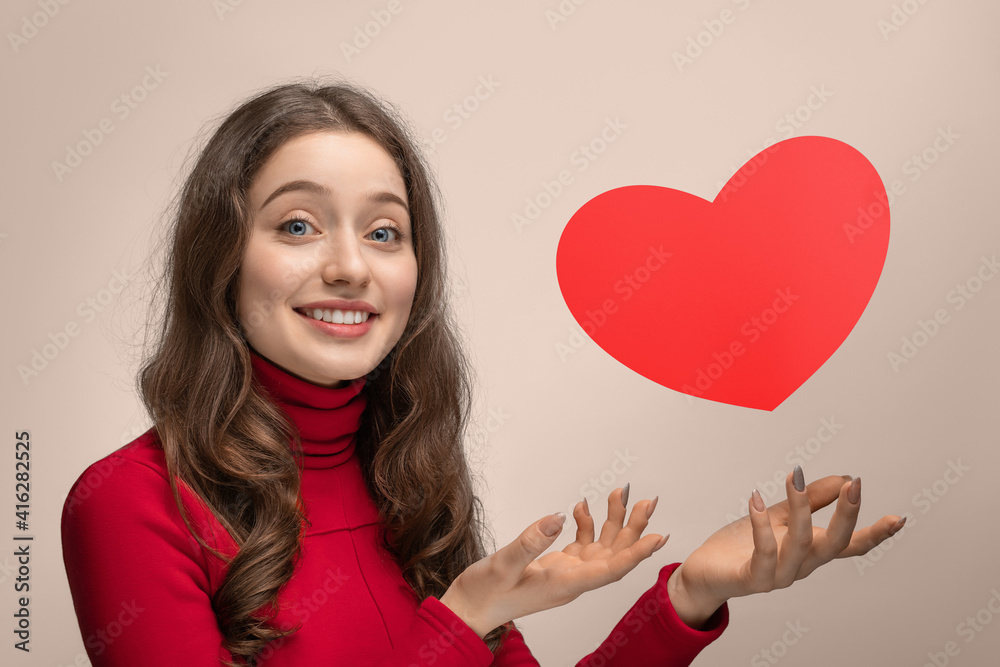 Girl with red cardboard heart, heart hanging in the air Girl with red cardboard heart, heart hanging in the air