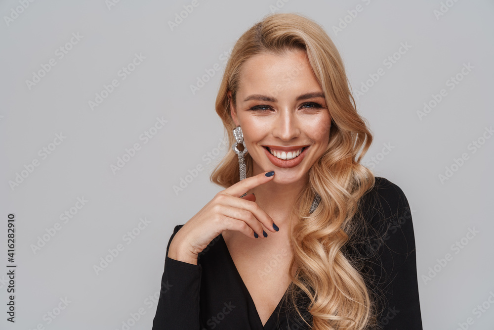 Happy blonde woman wearing fancy earrings smiling at camera Happy blonde woman wearing fancy earrings smiling at camera
