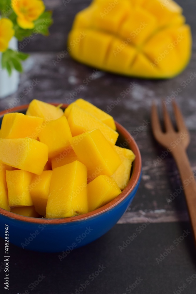 Diced mango cubes served on a bowl. Rustic background. Selective focus Diced mango cubes served on a bowl. Rustic background. Selective focus