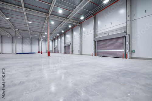 warehouse or hangar. Industrial building interior consist of polished concrete floor and closed door for product display or industry background.