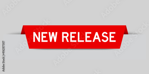 Red color inserted label with word new release on gray background