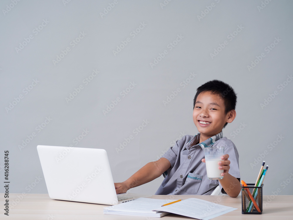 Little boy doing homework and drinking milk Little boy doing homework and drinking milk