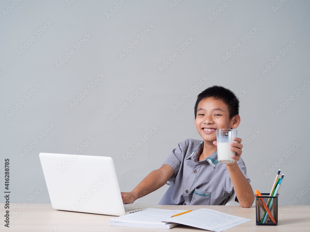 Little boy doing homework and drinking milk Little boy doing homework and drinking milk
