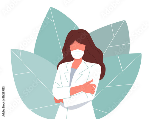  A young woman doctor. She wears a white medical gown and protective mask. 