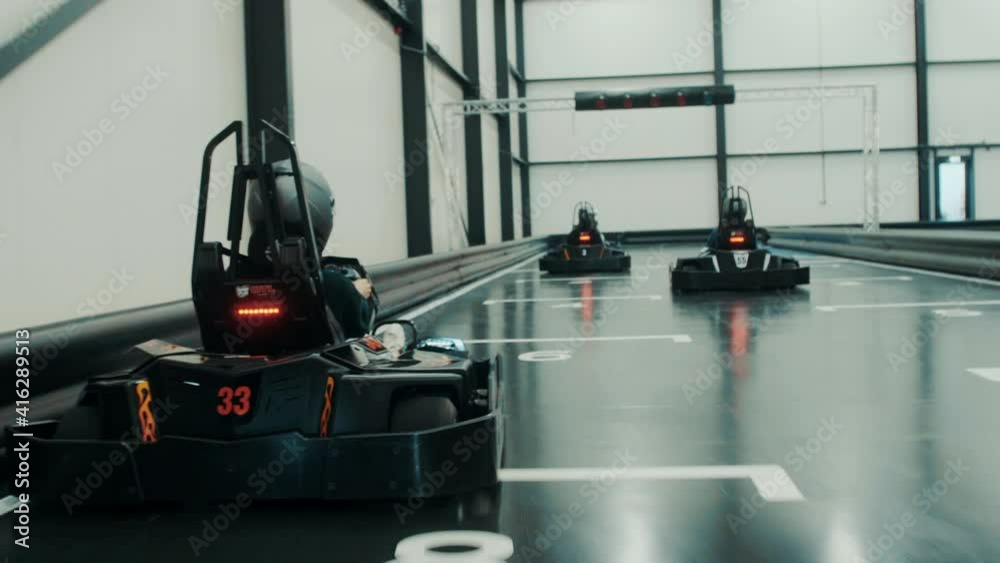 Racing electric go karts in an indoor track with friends