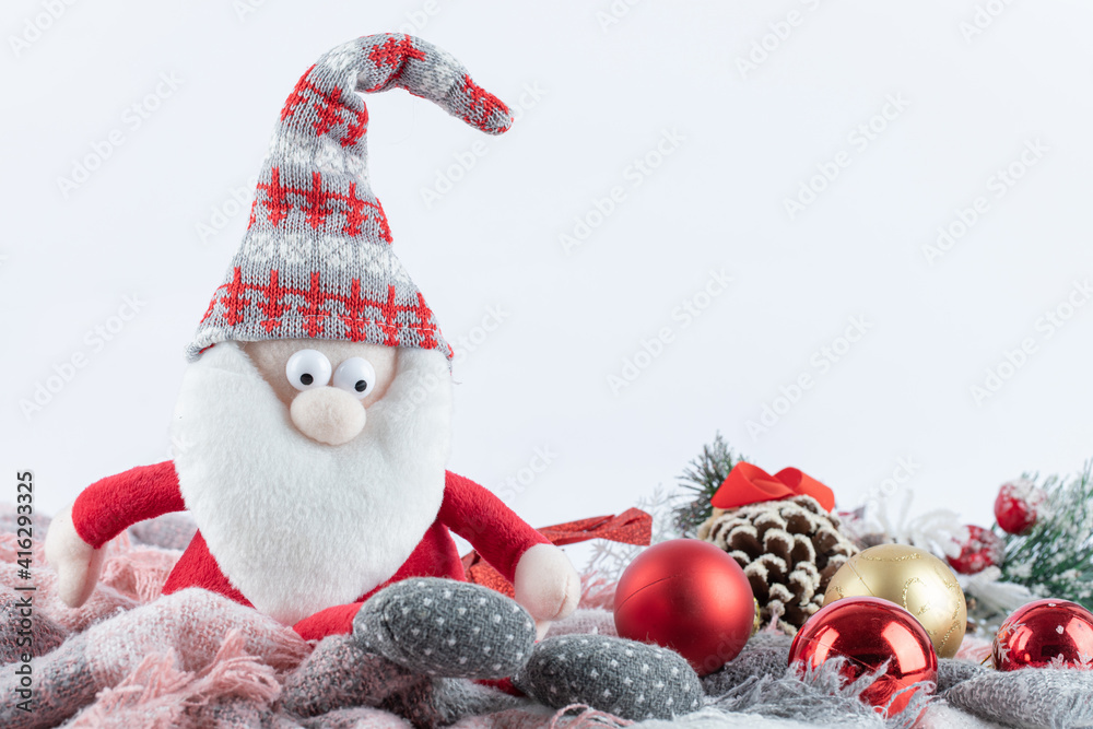 Santa figurine and festive baubles on white background