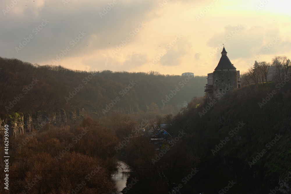 Aerial landscape view of Canyon of Smotrych River during winter sunset. Ancient watch tower (called Pottery Tower) in the top of the hill. Romantic and peaceful scene in Kamianets-Podilskyi, Ukraine