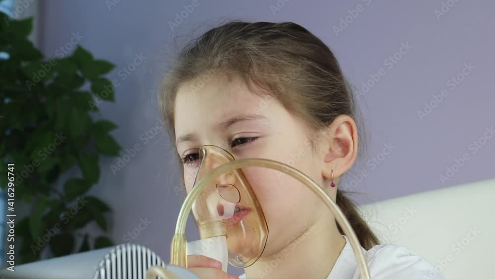 childhood asthma inhaling mask illnesses little baby girl with flu id doing aerosol independently . little girl is breathing with an inhaler