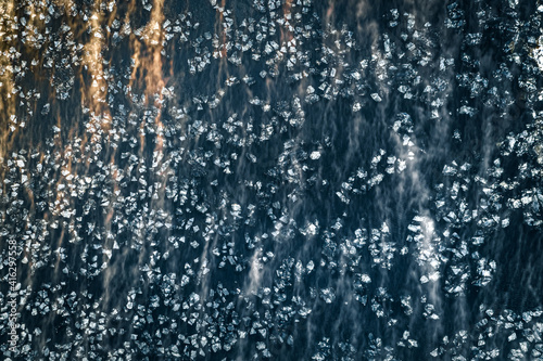 Ice blocks floating in dark waters covered in fog. Abstract landscape in sunny morning light. Picturesque shapes and forms. © Viesturs