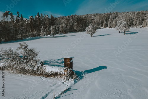 Snow overed landscape with high seat for huntig dear photo